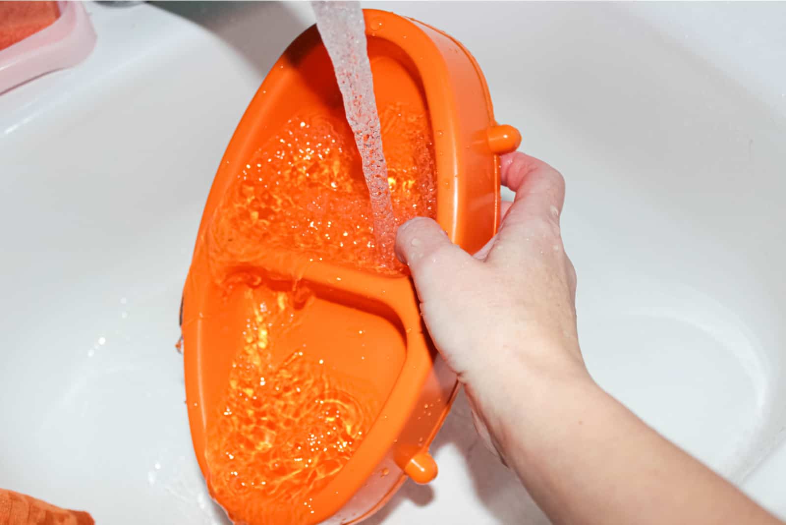 a woman washes a bowl of cat food