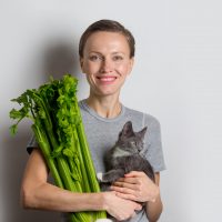 woman holding Celery and cat