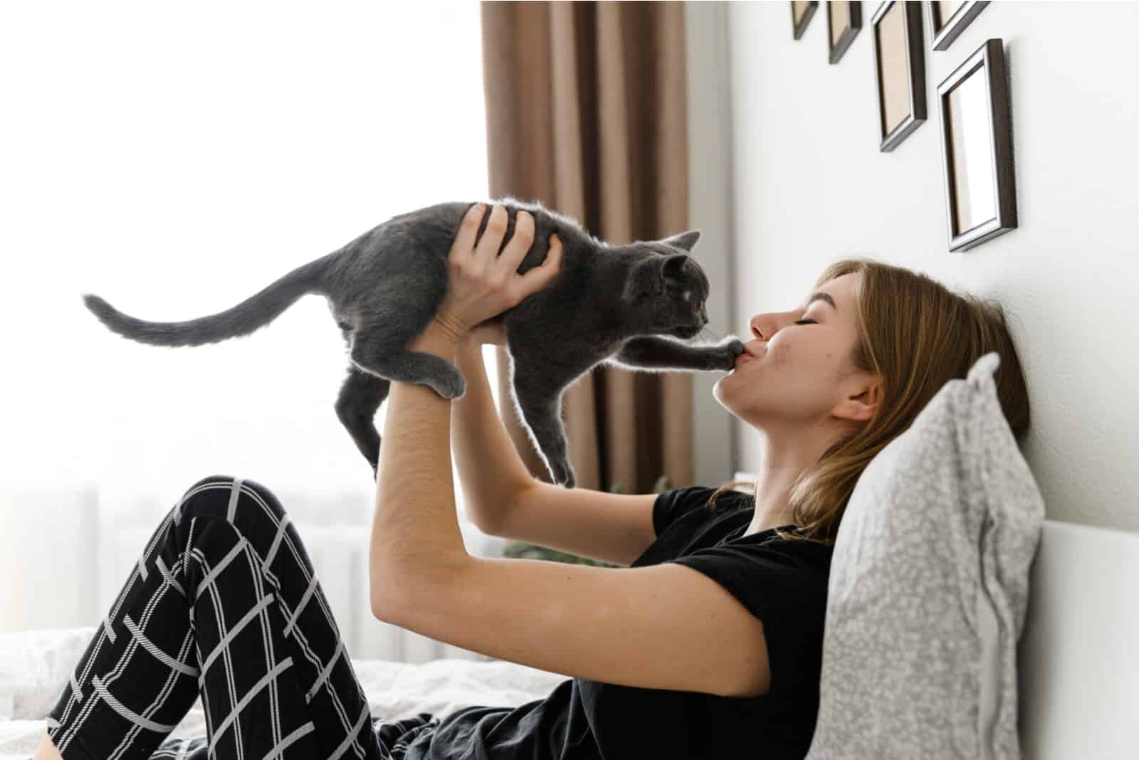 beautiful girl in pajamas holds her beloved pet in her arms