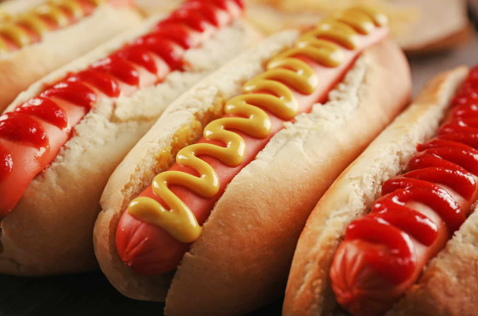 several hot dogs with sauces
