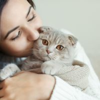 young woman kissing cat