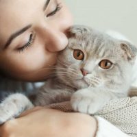 young woman kissing cat