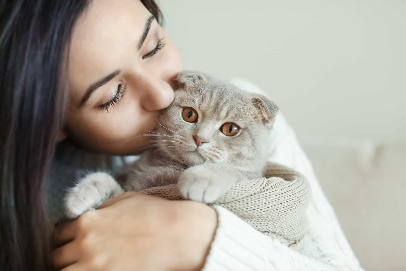 young woman kissing her cat