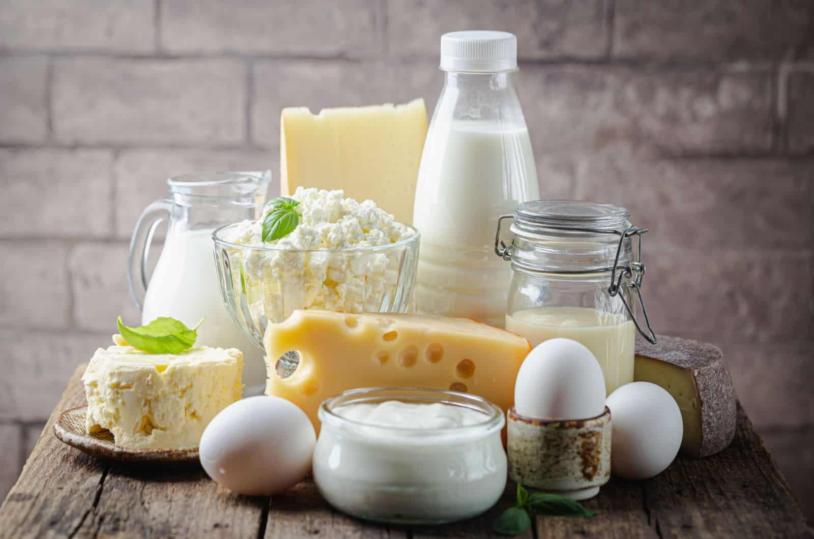 Fresh dairy products, milk, cottage cheese, eggs, yogurt, sour cream and butter on wooden table