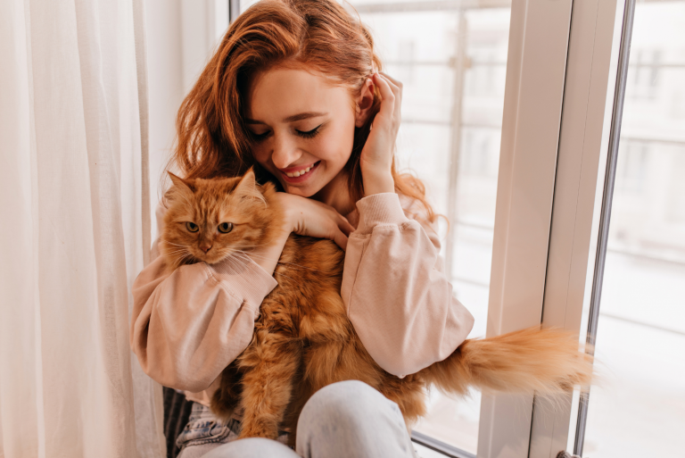 smiling woman in her arms with a cat