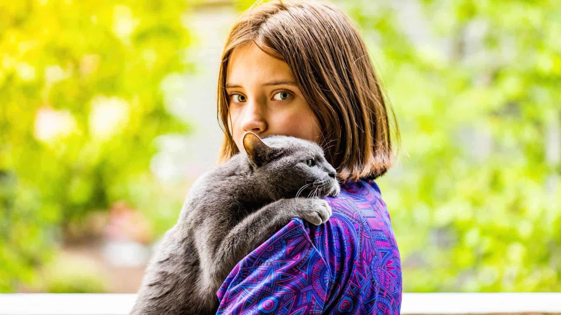 girl holding a russian blue cat