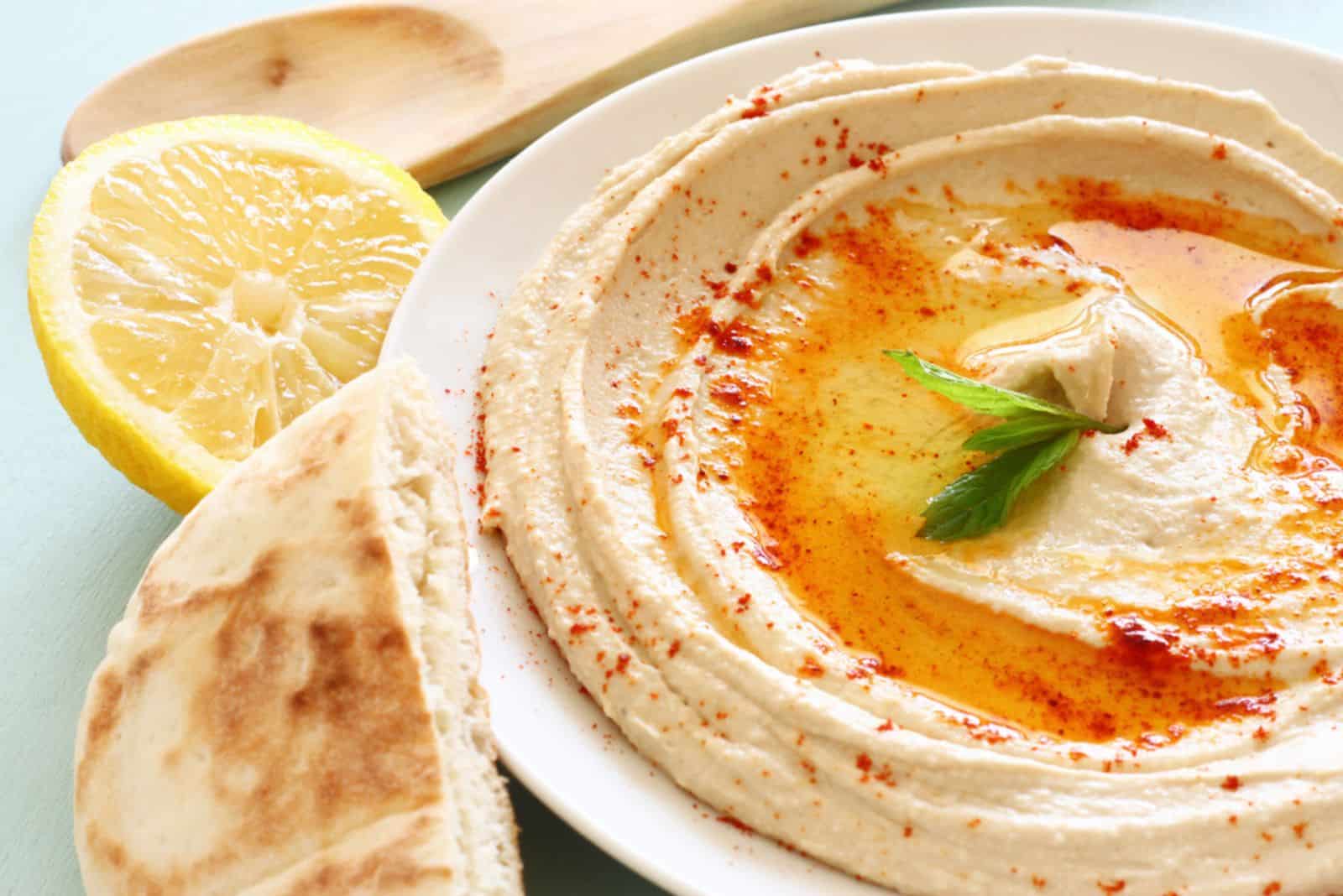 hummus dip plate and lemon on wooden table