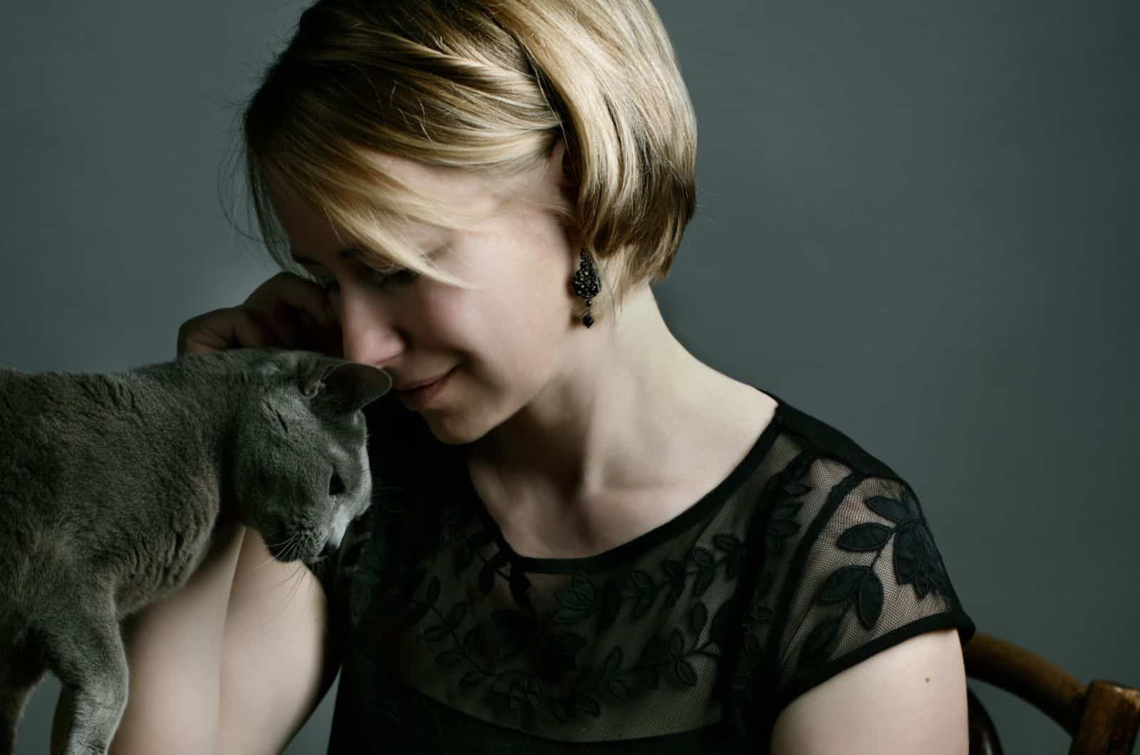 woman cuddling with her russian blue cat