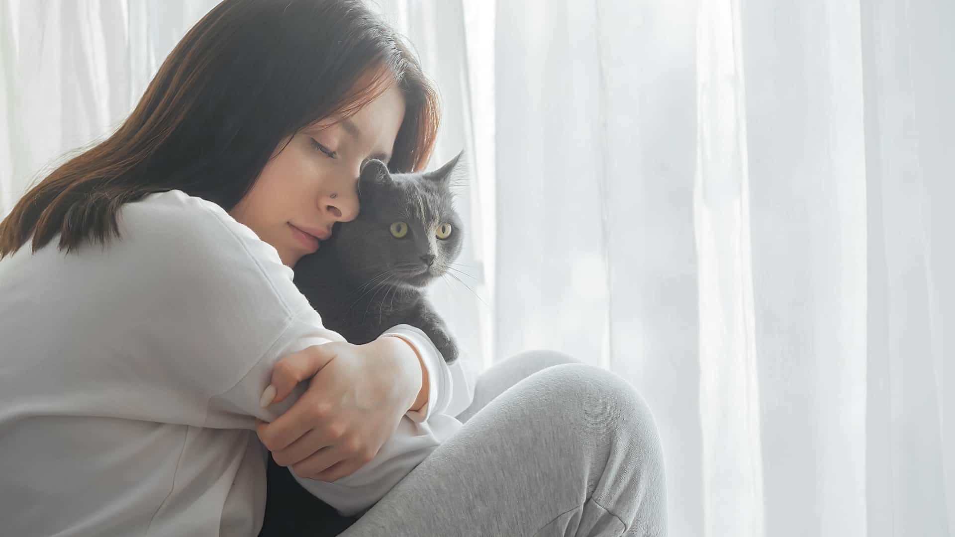 sad woman holds cat