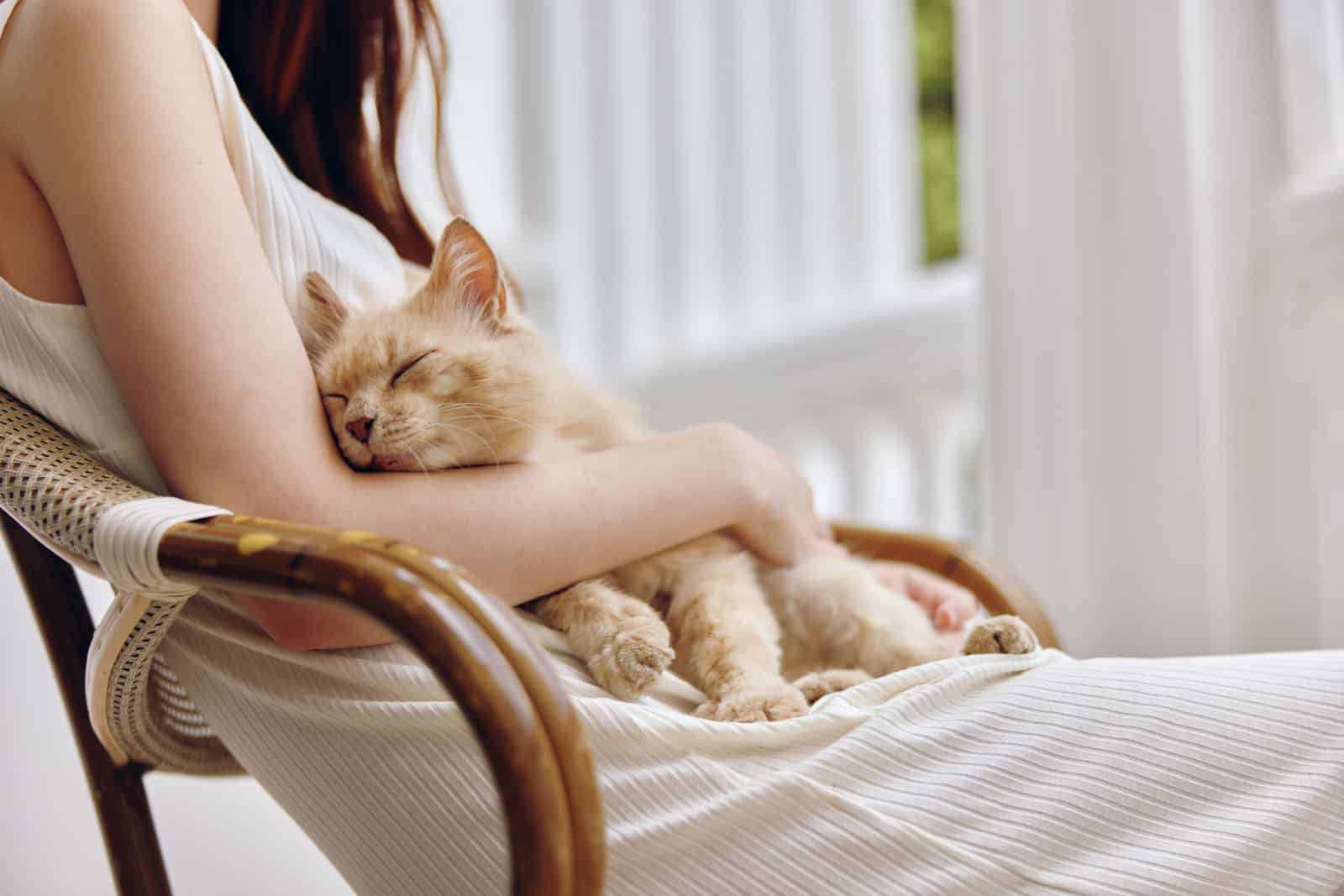 Woman in white dress together with the cat on the terrace