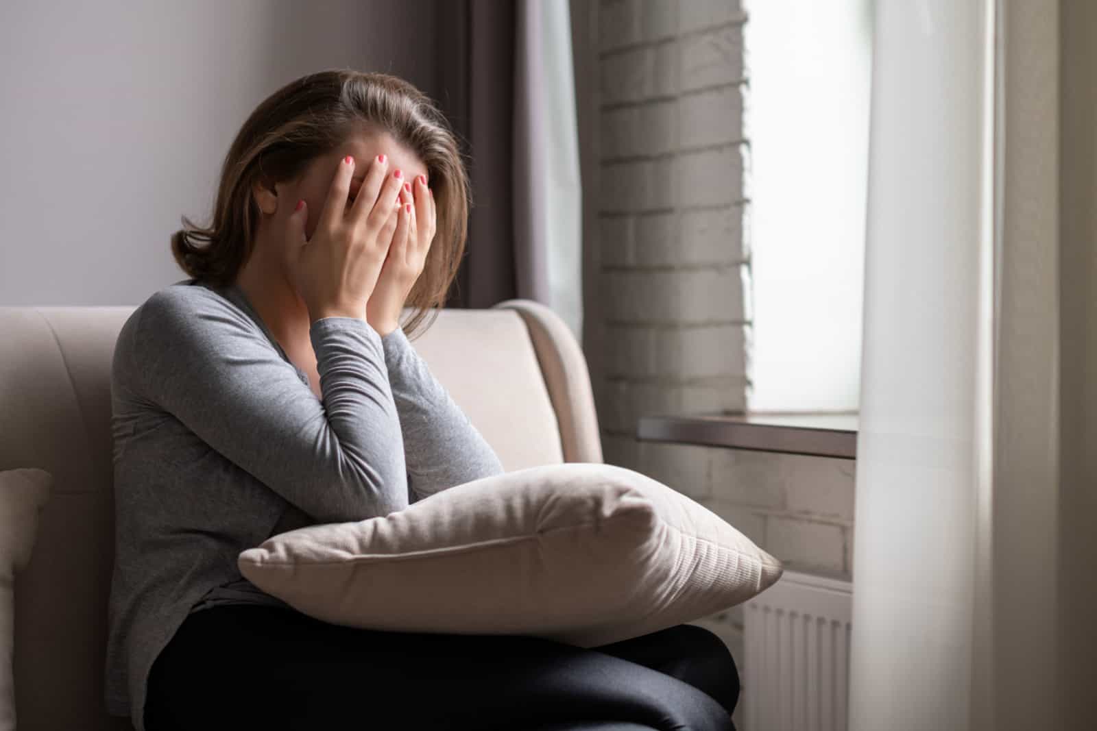 woman covering her face with hands and crying