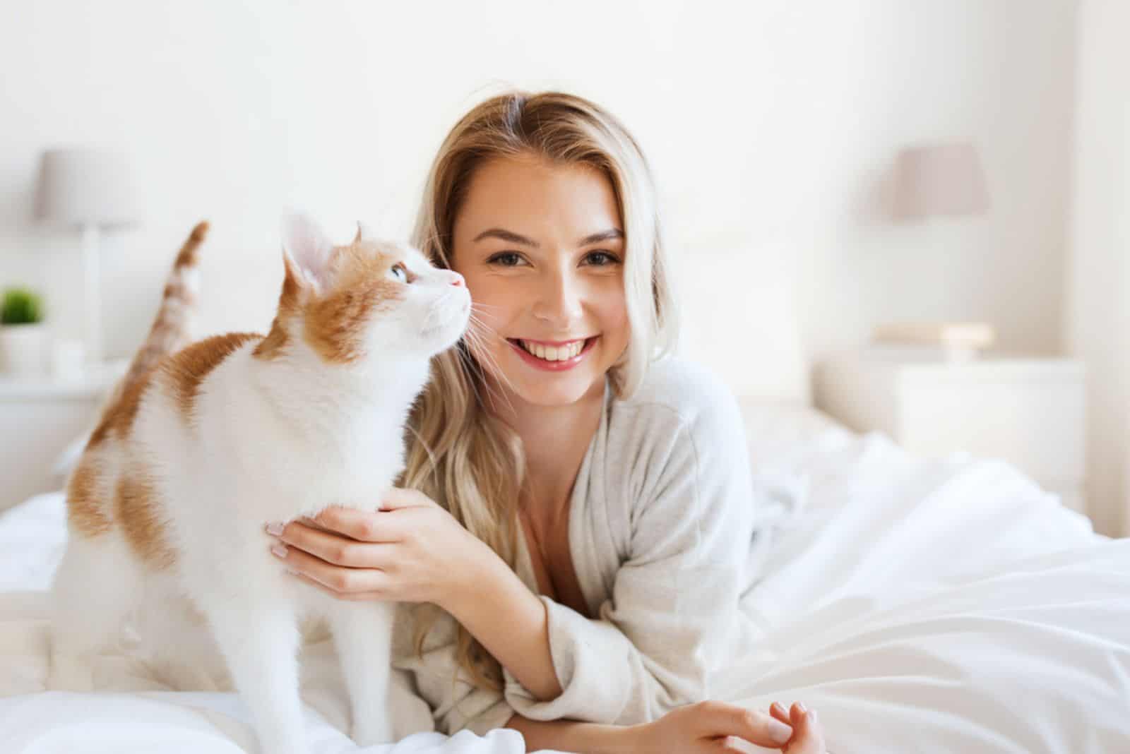  young woman with cat in bed 