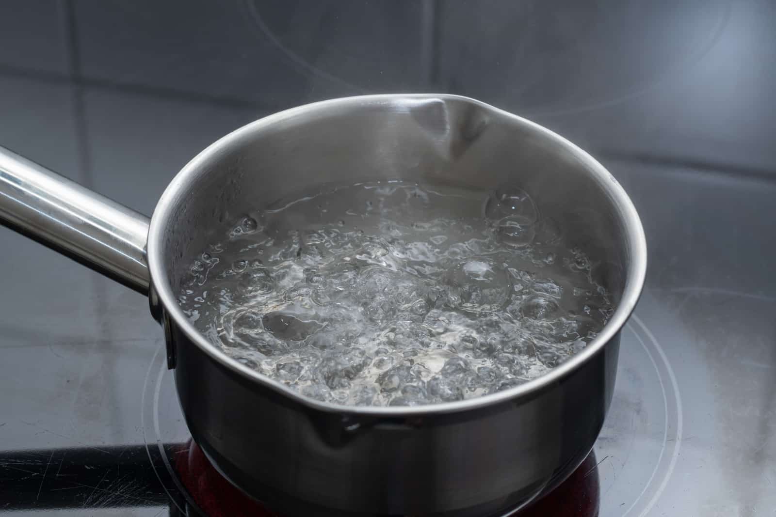 Boiling water in pan in kitchen