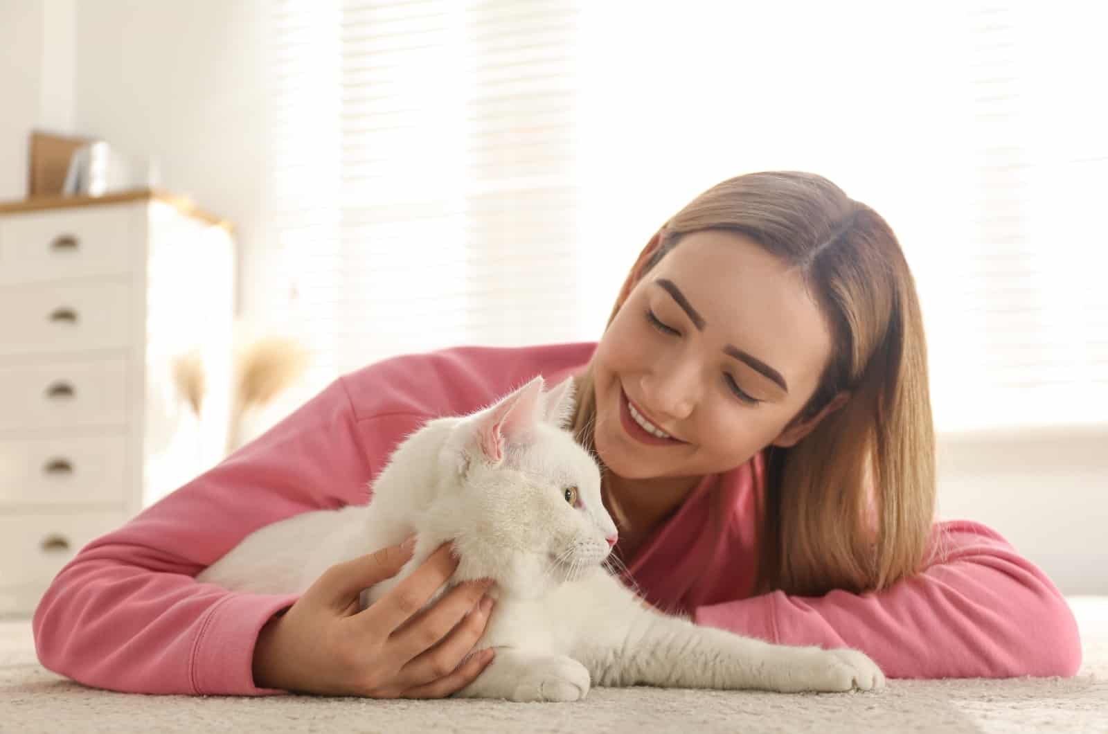 blonde woman petting white cat