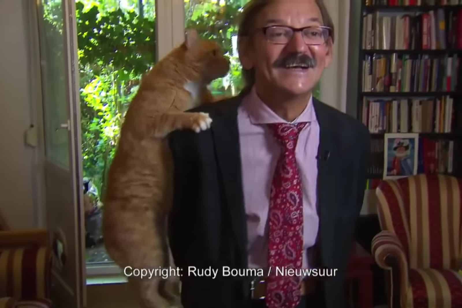 the cat climbed onto the man's shoulder