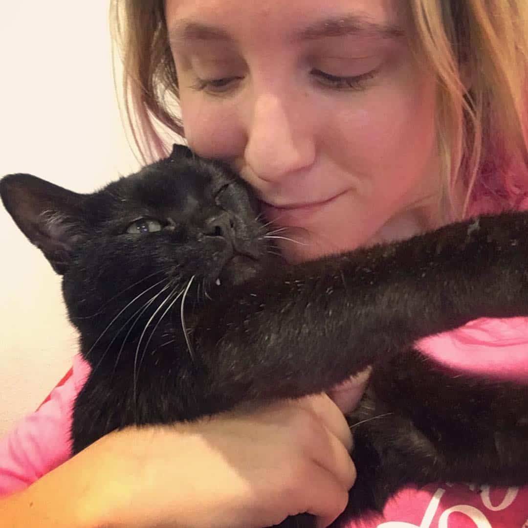 a one-eared cat in a woman's arms