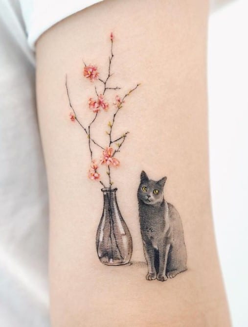 a cat tattoo and a vase with red flowers