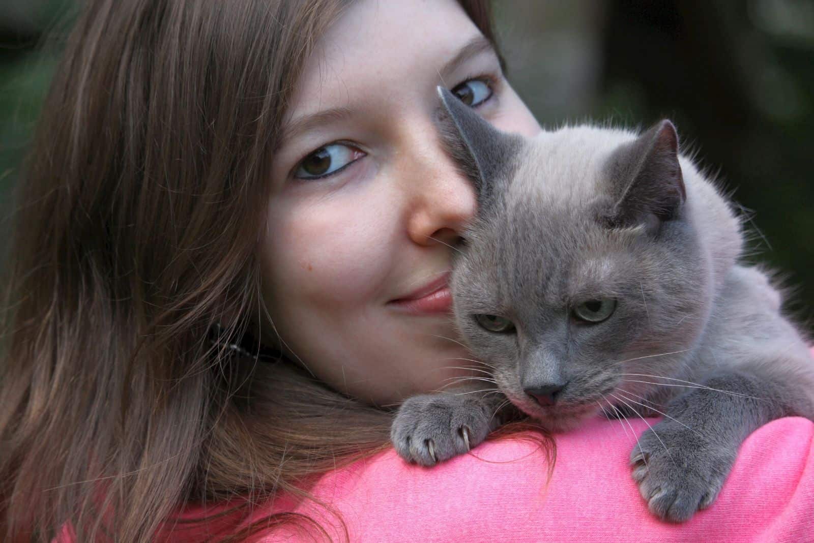a gray cat on a woman's shoulder