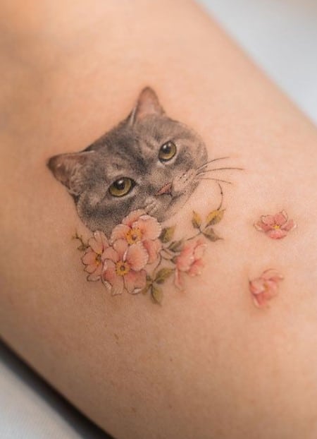 cat head and pink flowers tattoo