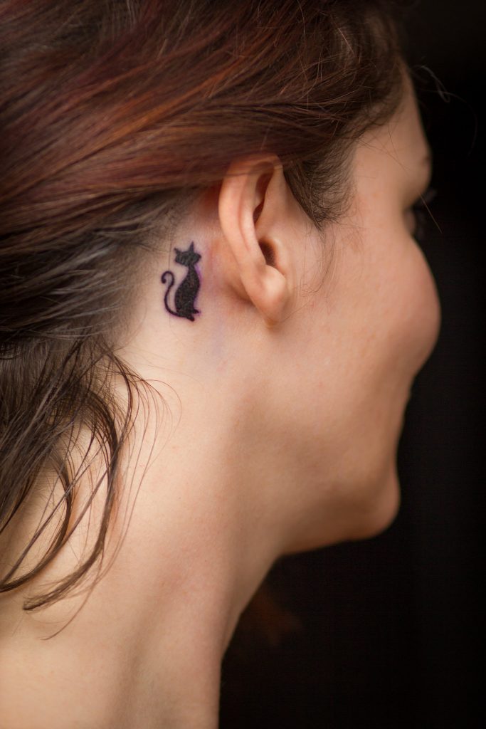 cat tattoo behind a woman's ear