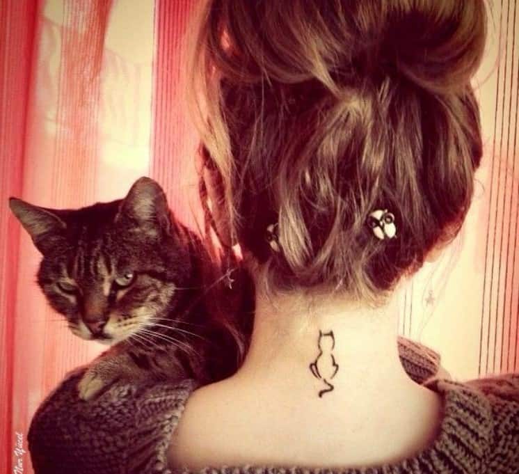 cat tattoo on the neck of a woman holding a cat in her arms