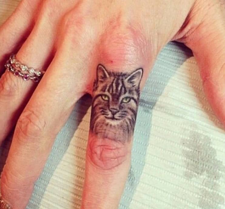 cat tattoo on woman's finger