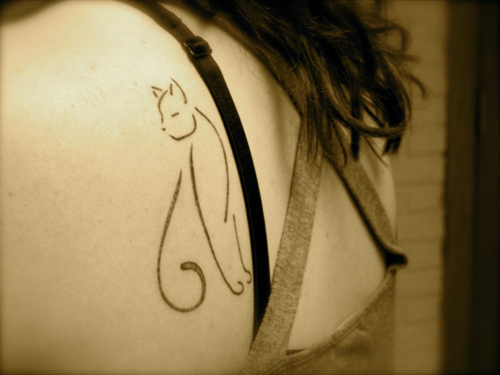 cat tattoo on woman's shoulder