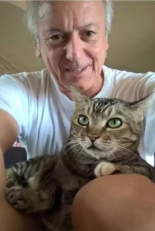 senior man taking a selfie with cat