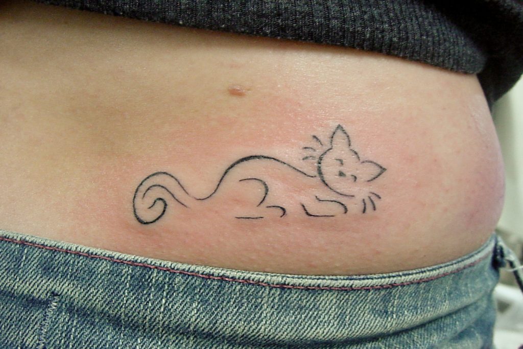 tattoo of a cat sleeping on its stomach