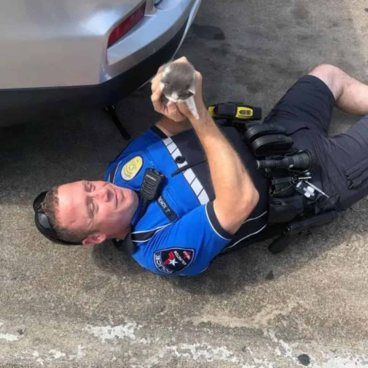 a cheerful policeman after rescuing a kitten