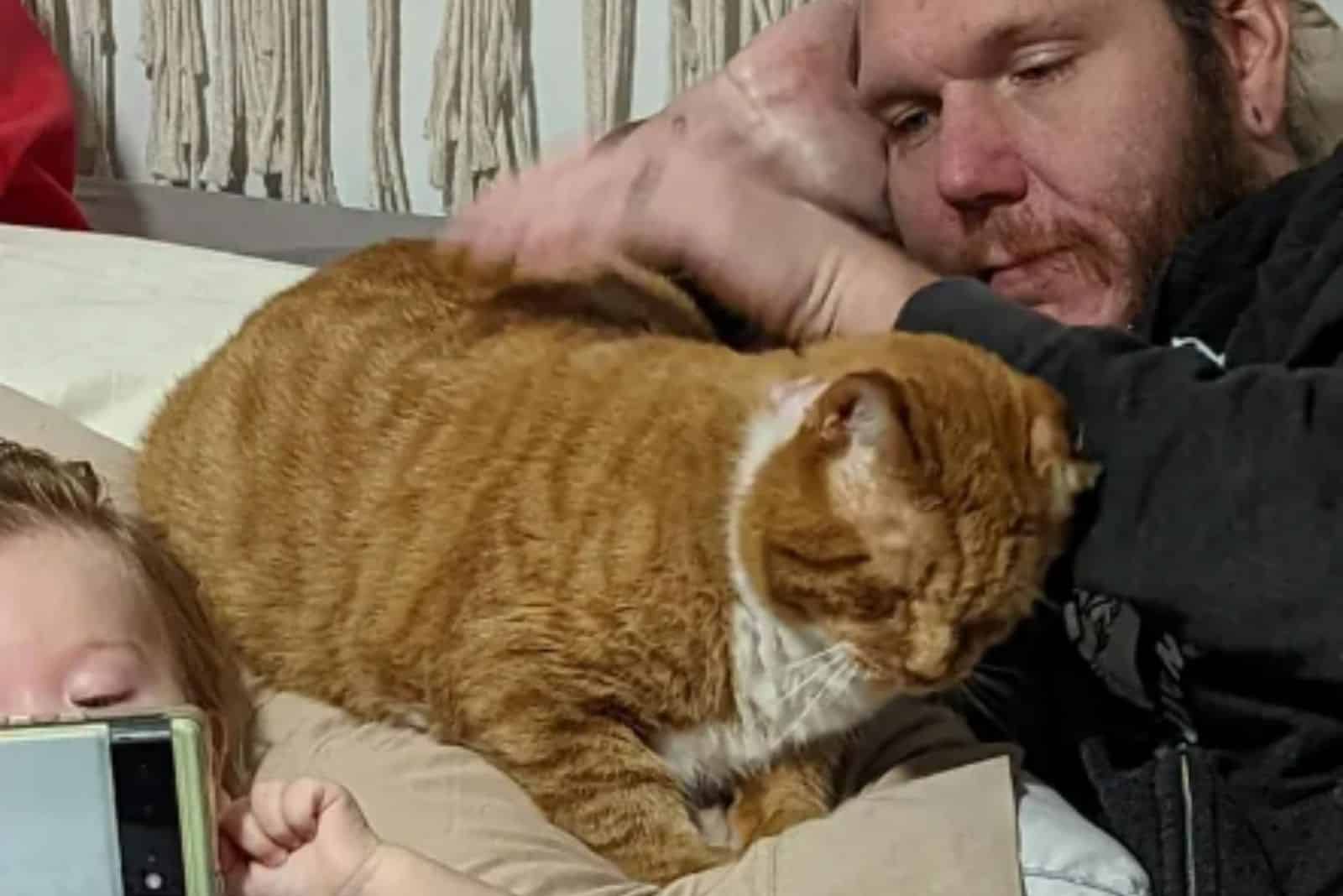 a rescued cat in the company of a man and a child