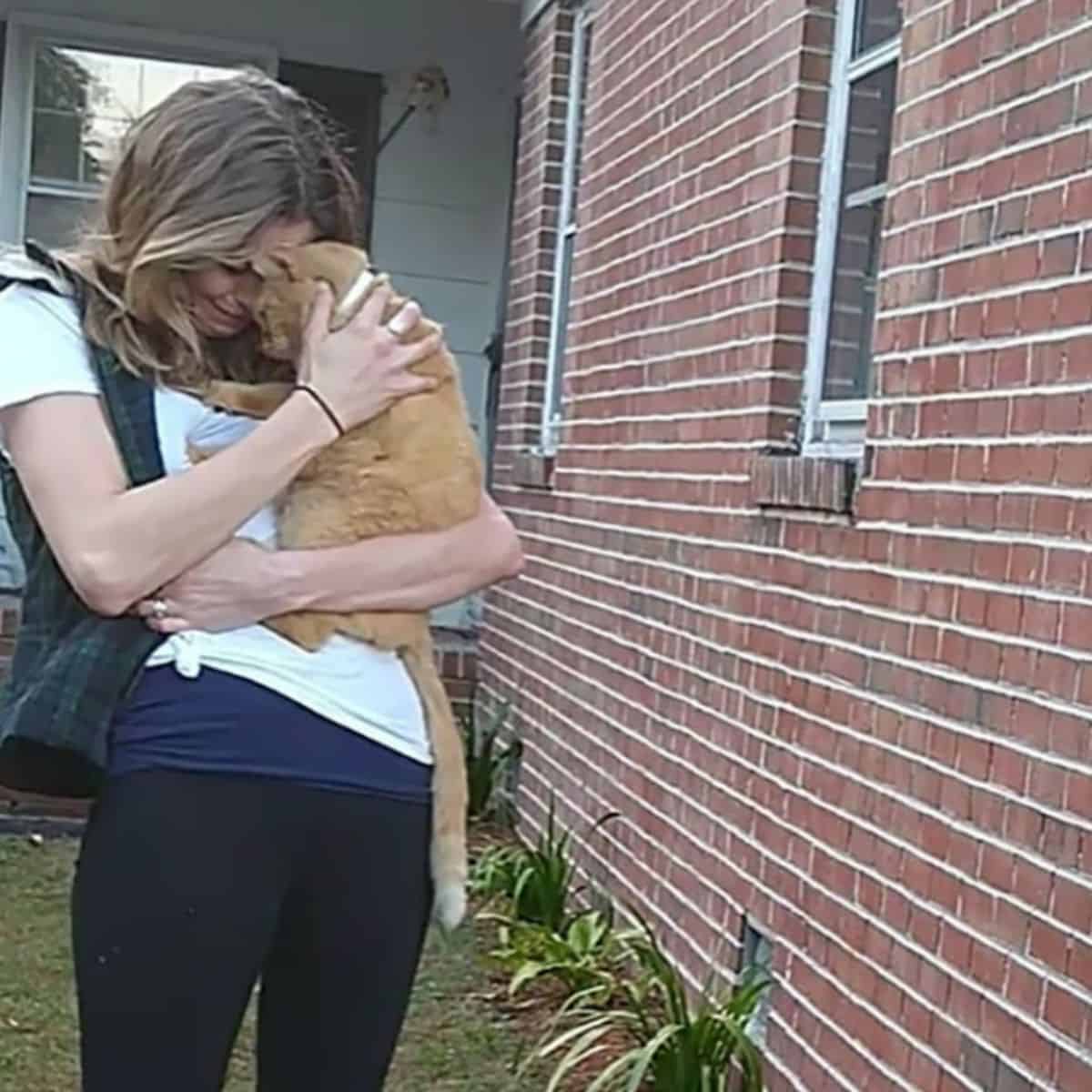 a woman hugs a cat that has returned