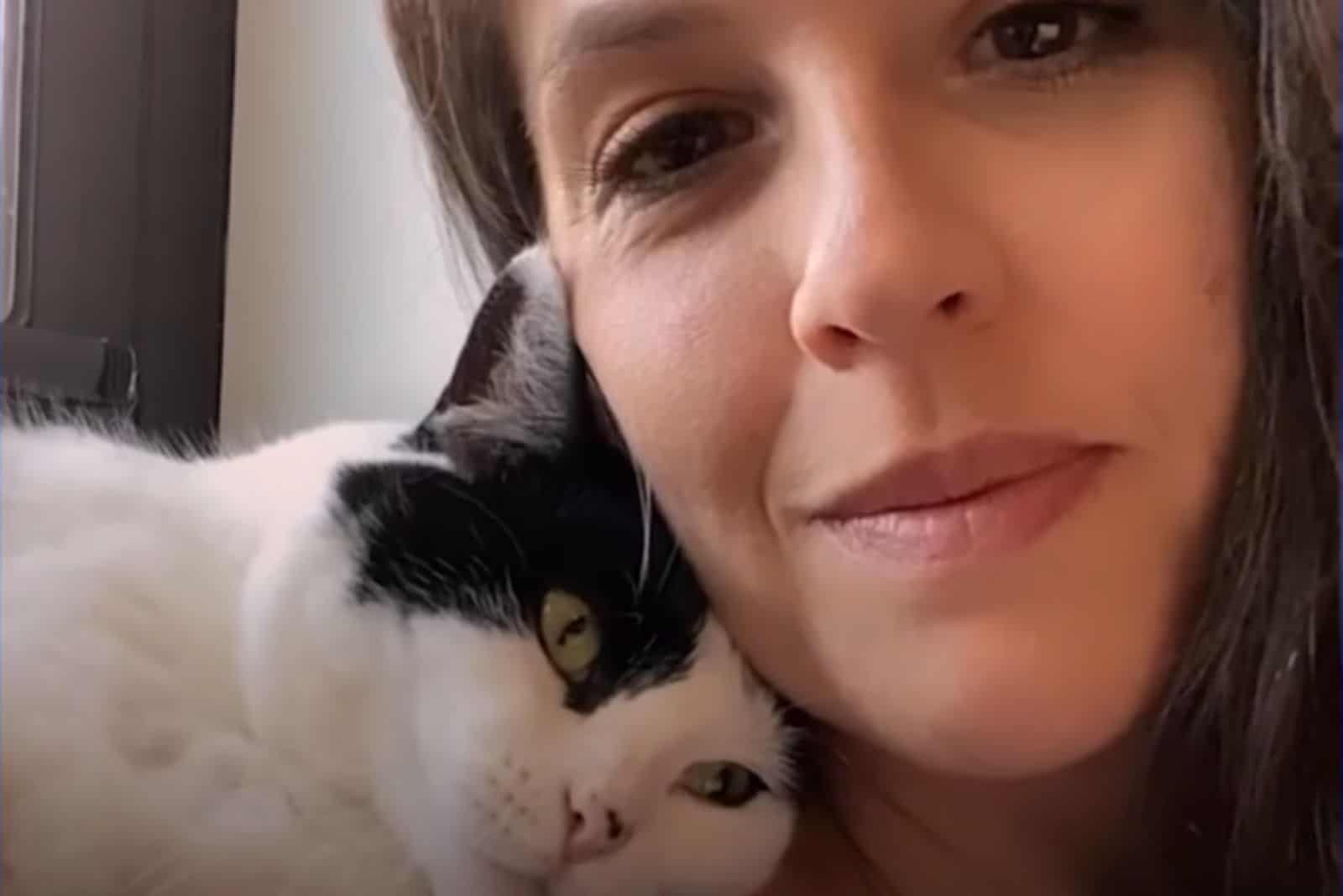 cat snuggling with woman
