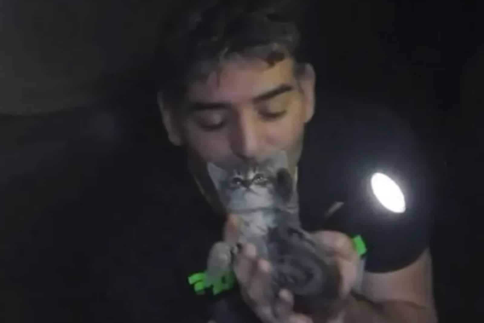man saves a kitten in a storm drain
