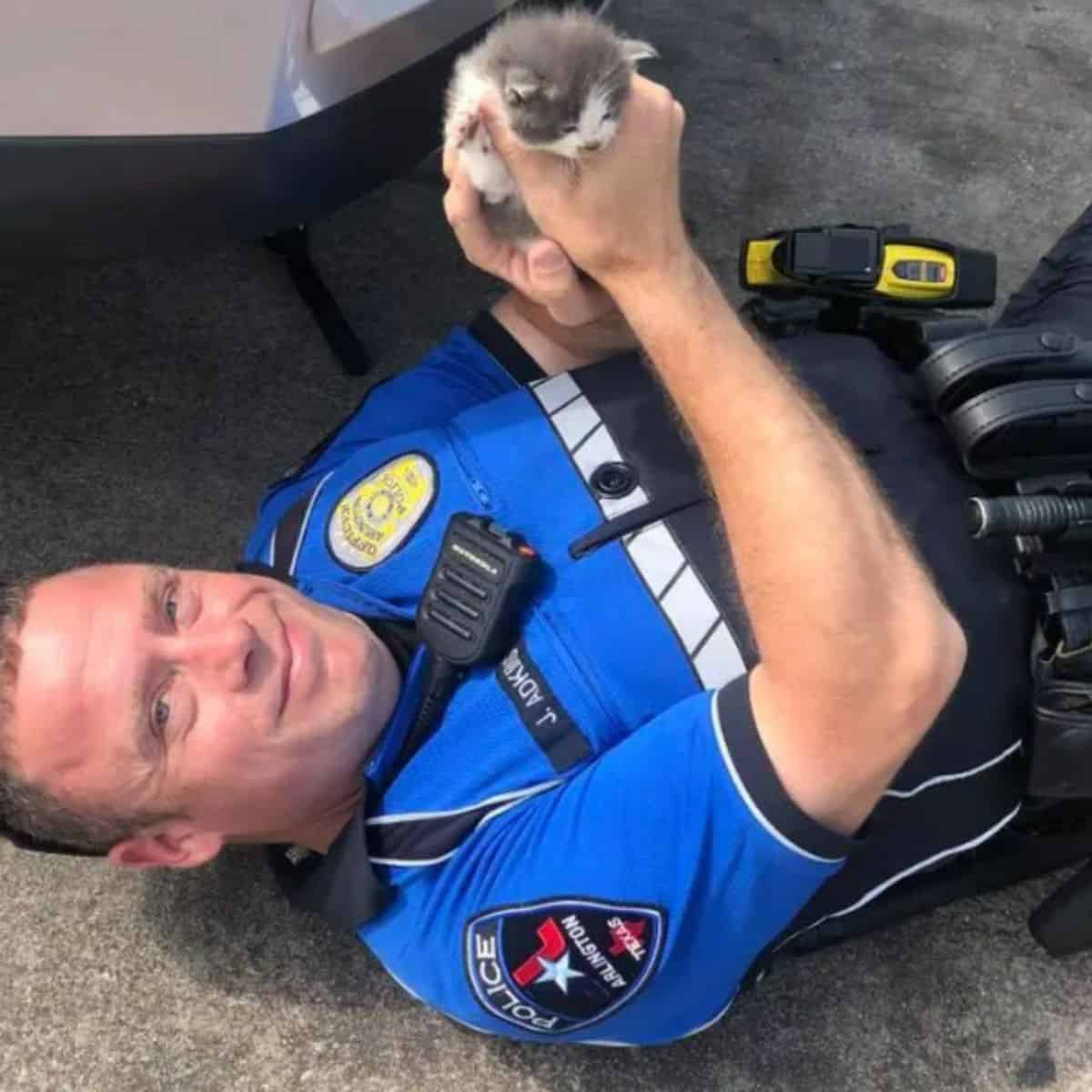 the policeman saved the cute kitten from under the car