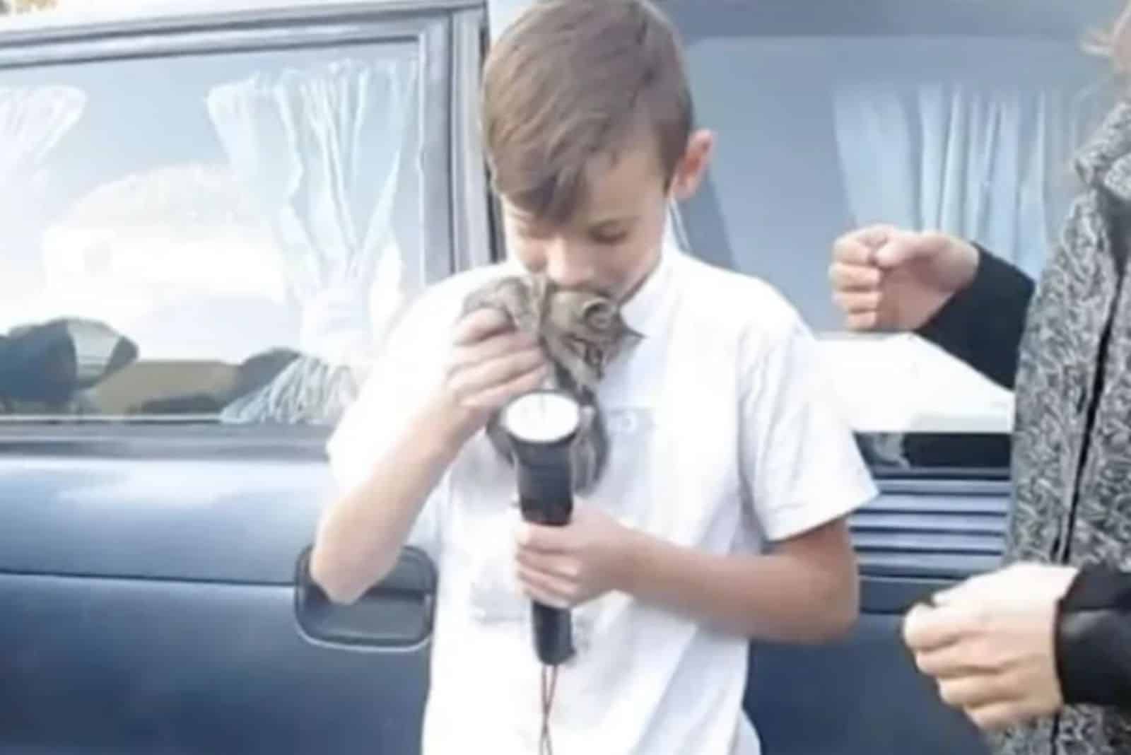 young boy holding the rescued kitten
