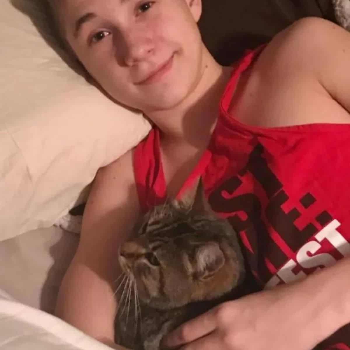 boy laying with cat