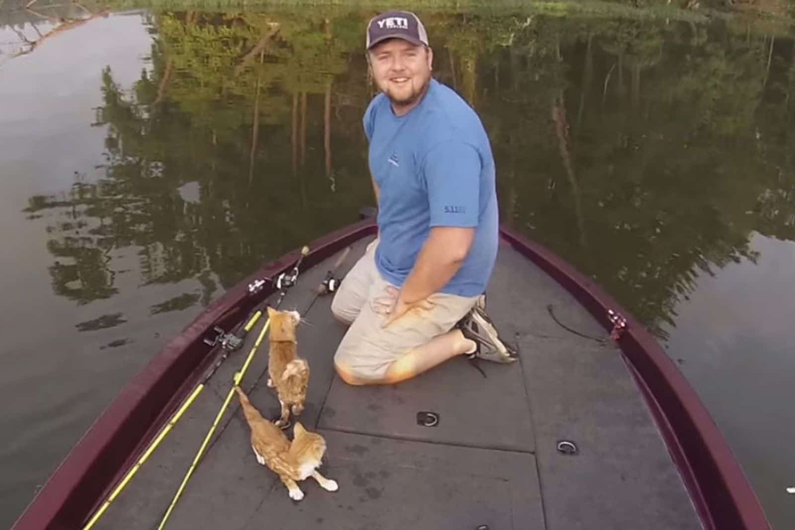 happy fisherman with two rescued kittens