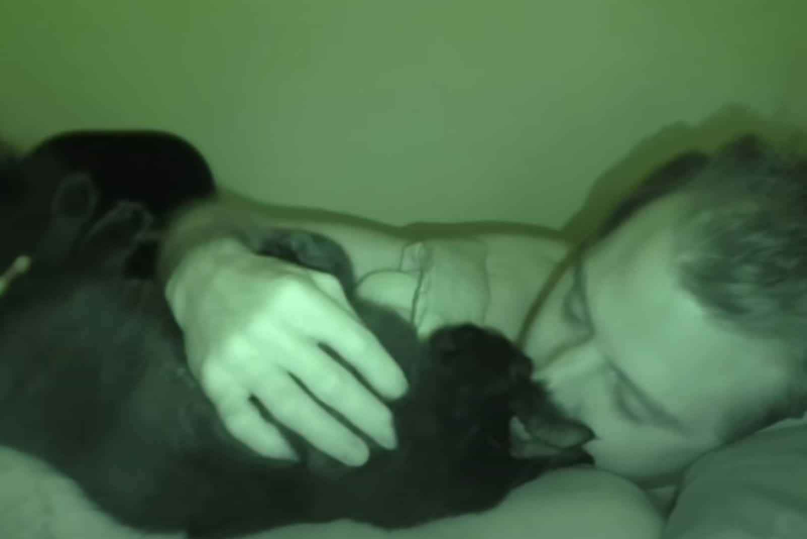 man kissing cat in the dark