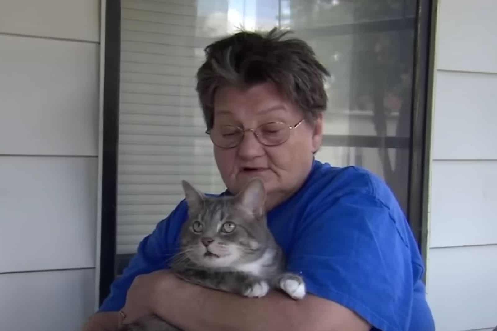 the cat enjoys the woman's arms