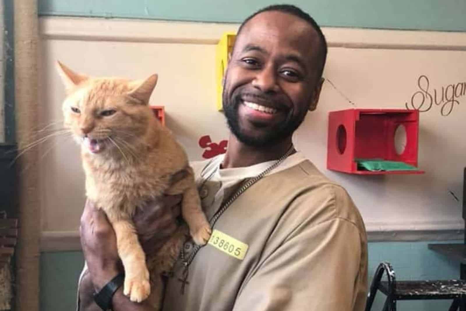 Man holding orange cat