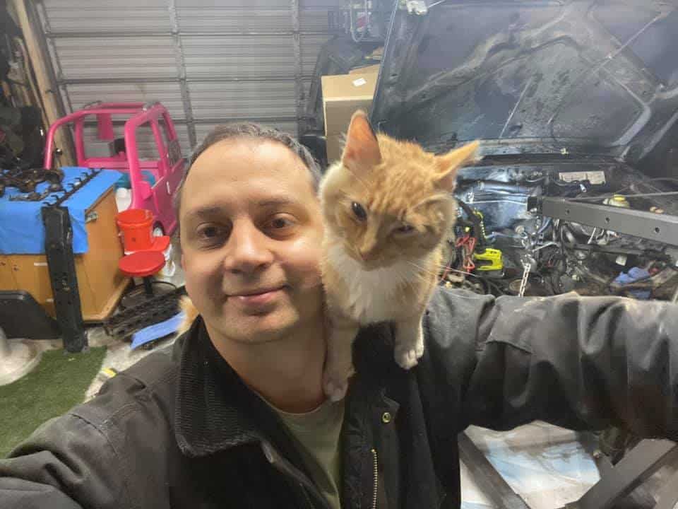 smiling man with cat on shoulder