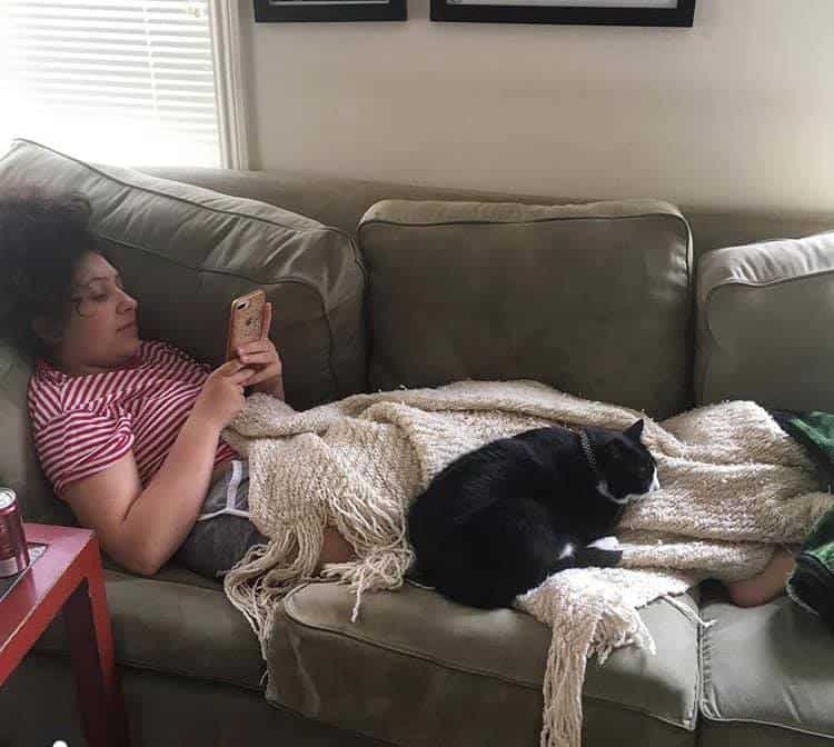 woman laying on the couch with therapy cat