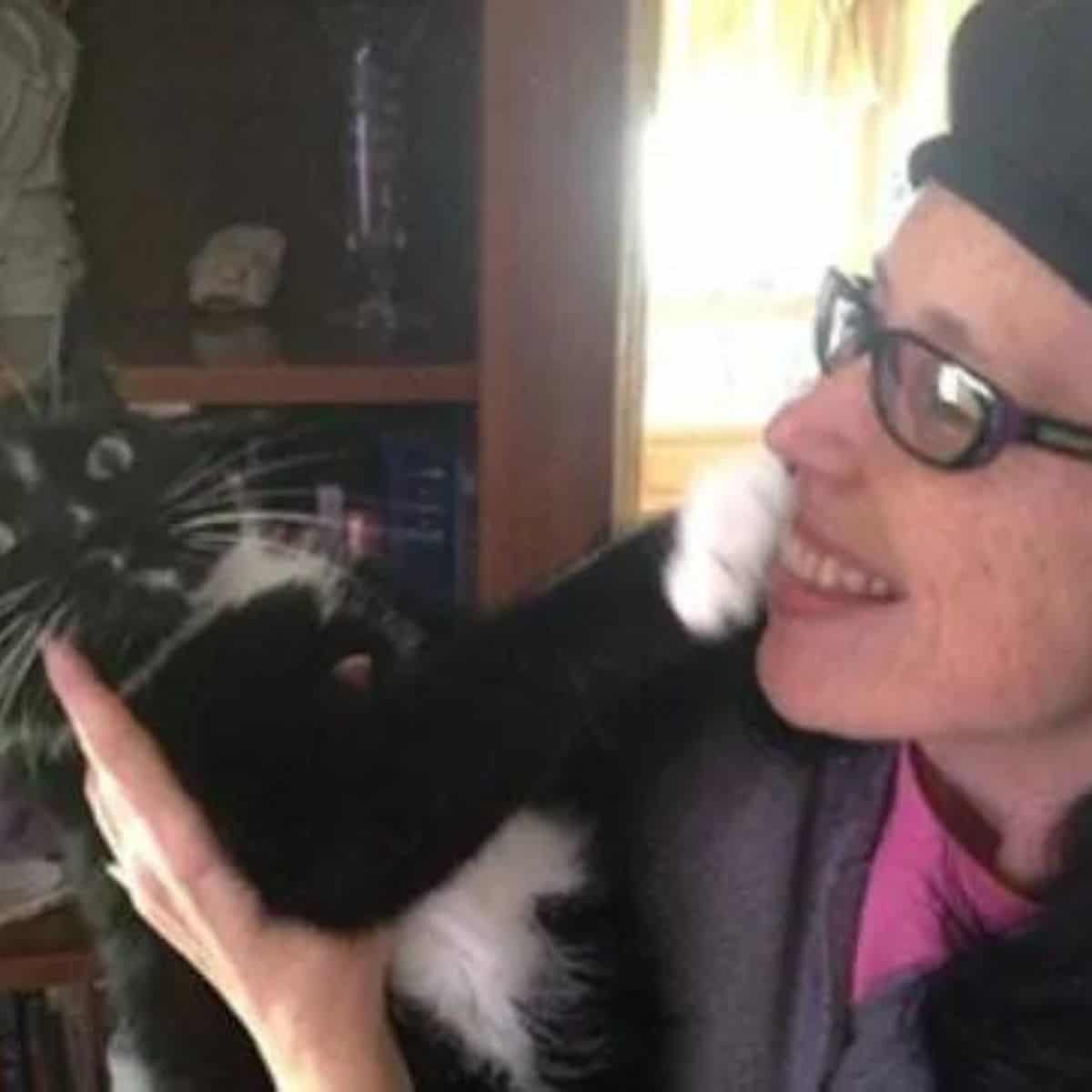 the cat defends itself from the woman with its paw