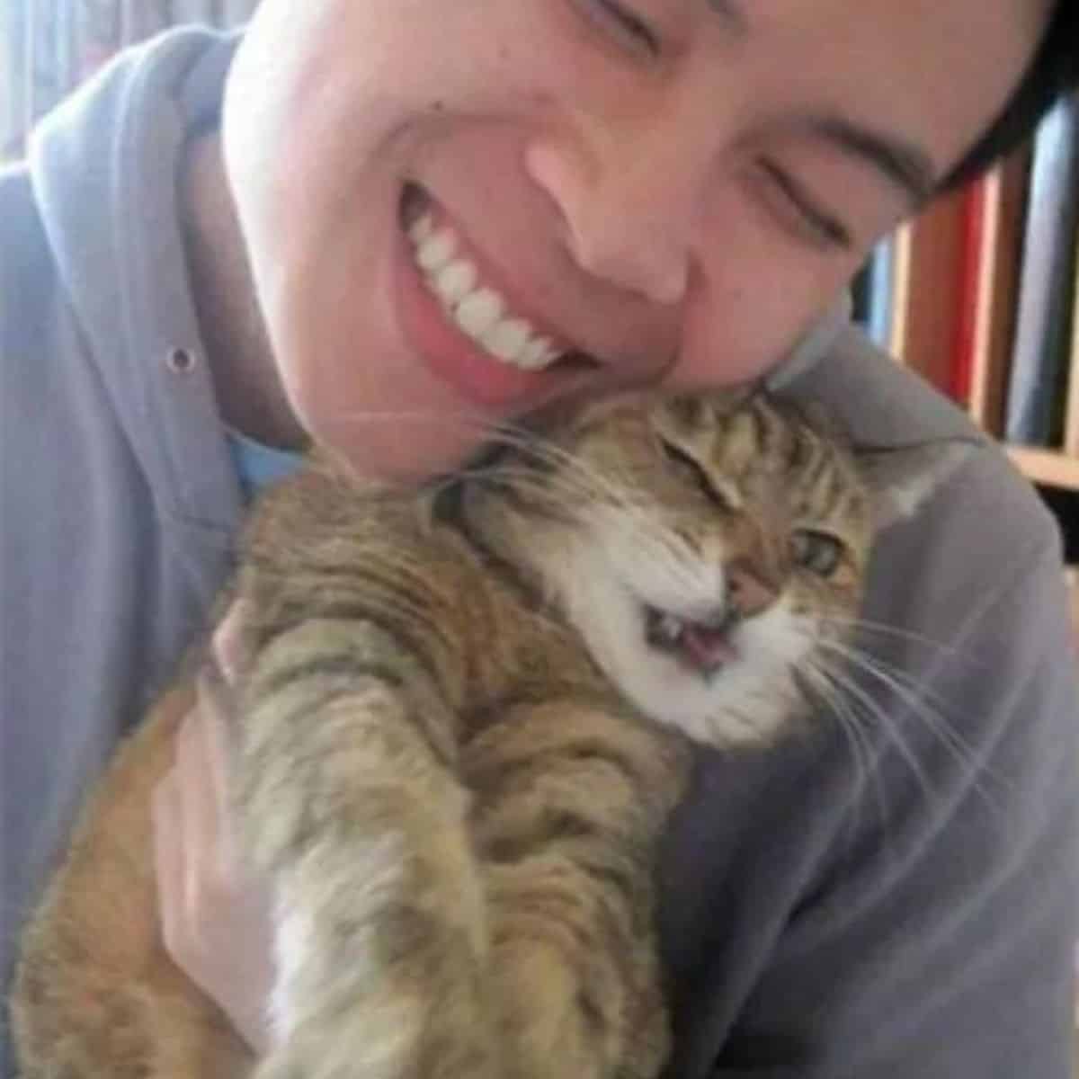 the cat makes faces in the woman's arms