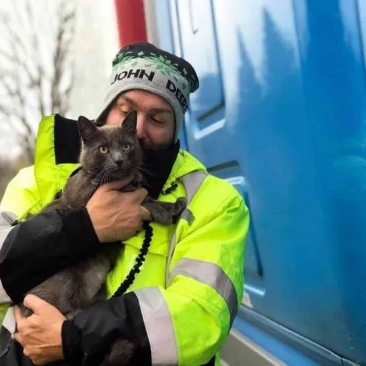 the truck driver holds his cat in his arms