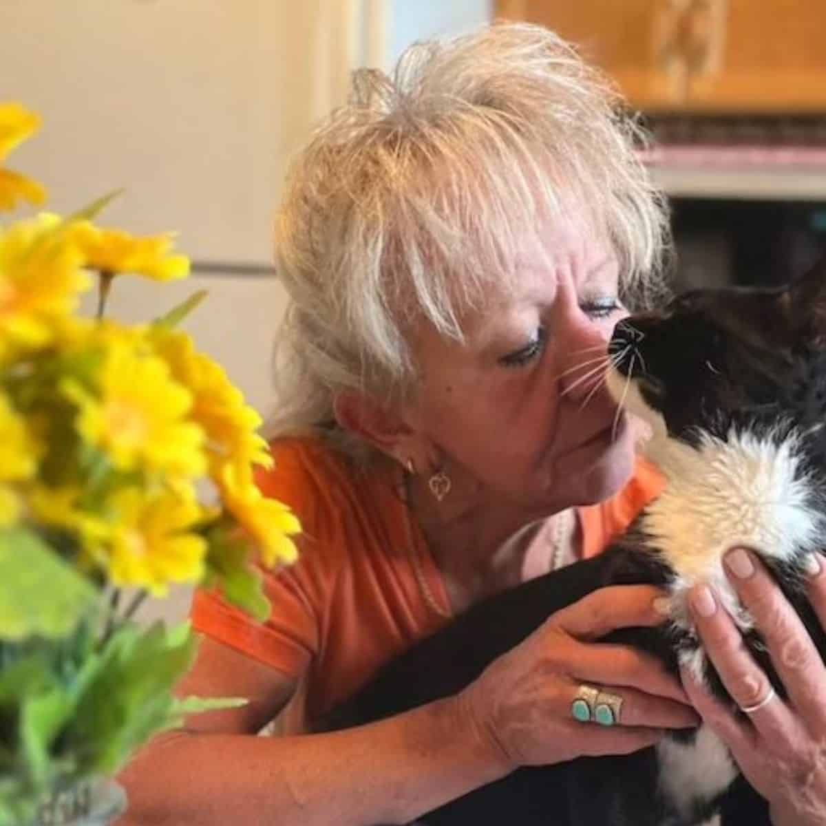 old woman kissing the cat