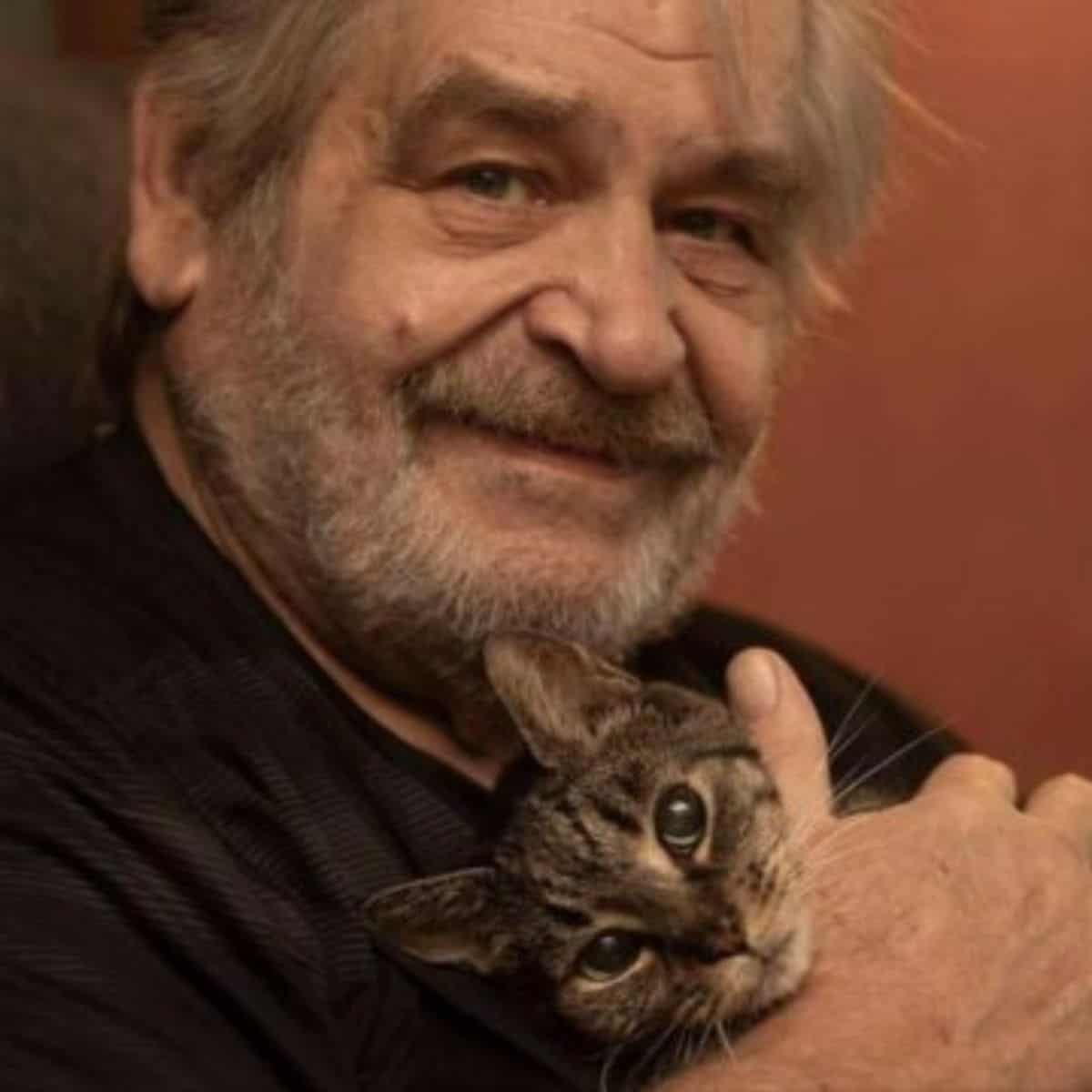 portrait of a man holding a cat in his arms