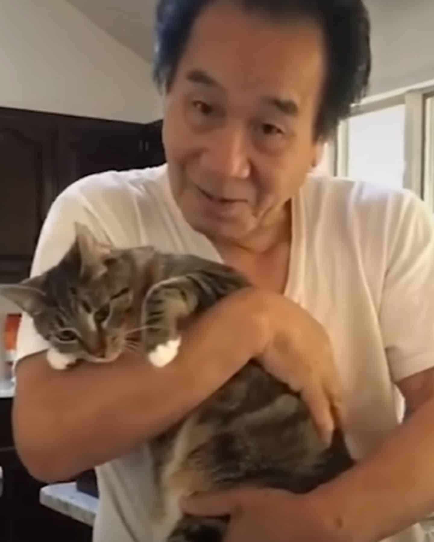 Asian guy holding a cat