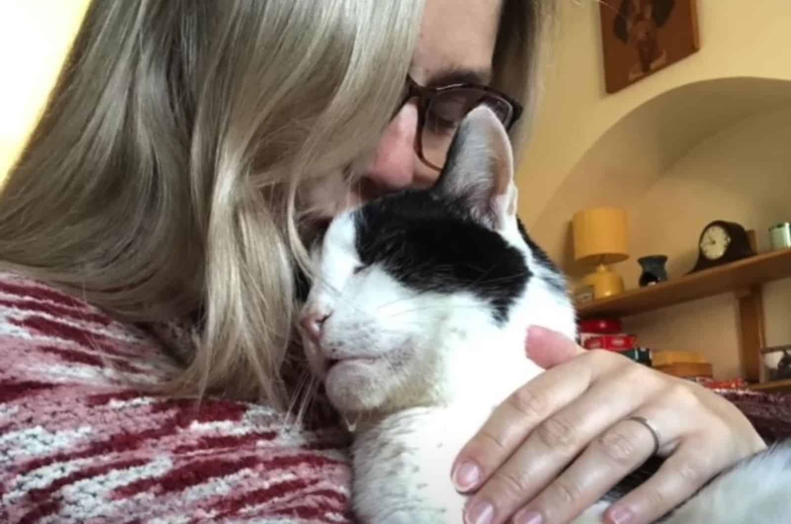 girl with glasses hugging a cat